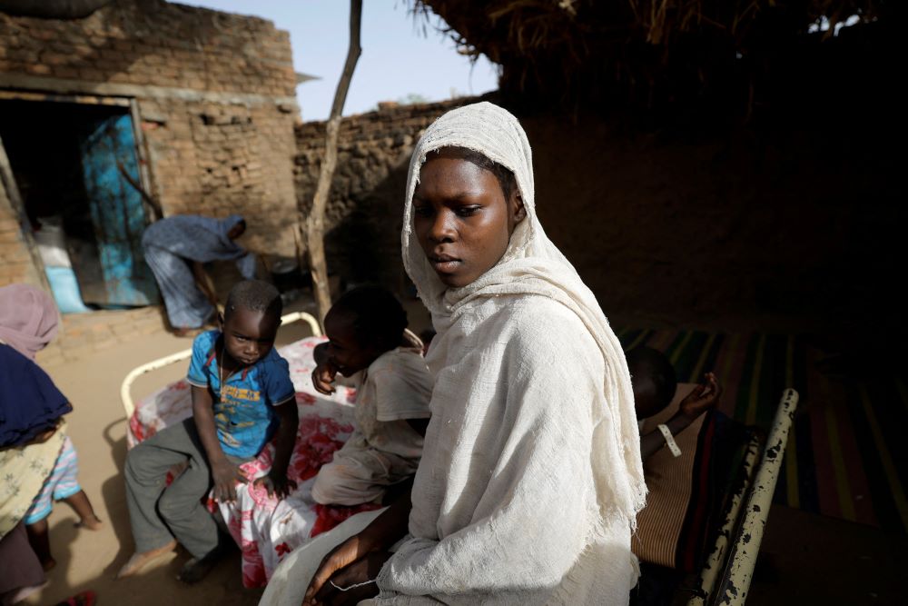 A young Sudanese woman who fled the violence in Sudan's Darfur region stands in the yard of a Chadian's family house May 14, 2023. She took refuge at the house in Koufroun, Chad, near the border between that country and Sudan. 