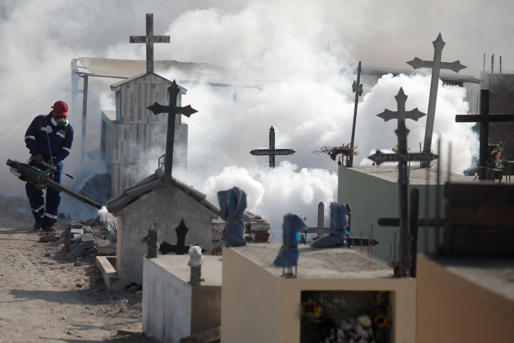 A health worker sprays fumigation vapor to stem the spread of dengue virus at the Nueva Esperanza cemetery in Lima, Peru, June 1, 2022. This year, Peru is going through one of the worst dengue epidemics in its history and has become the country with the second highest number of cases in the Americas. (OSV News photo/Sebastian Castaneda, Reuters)