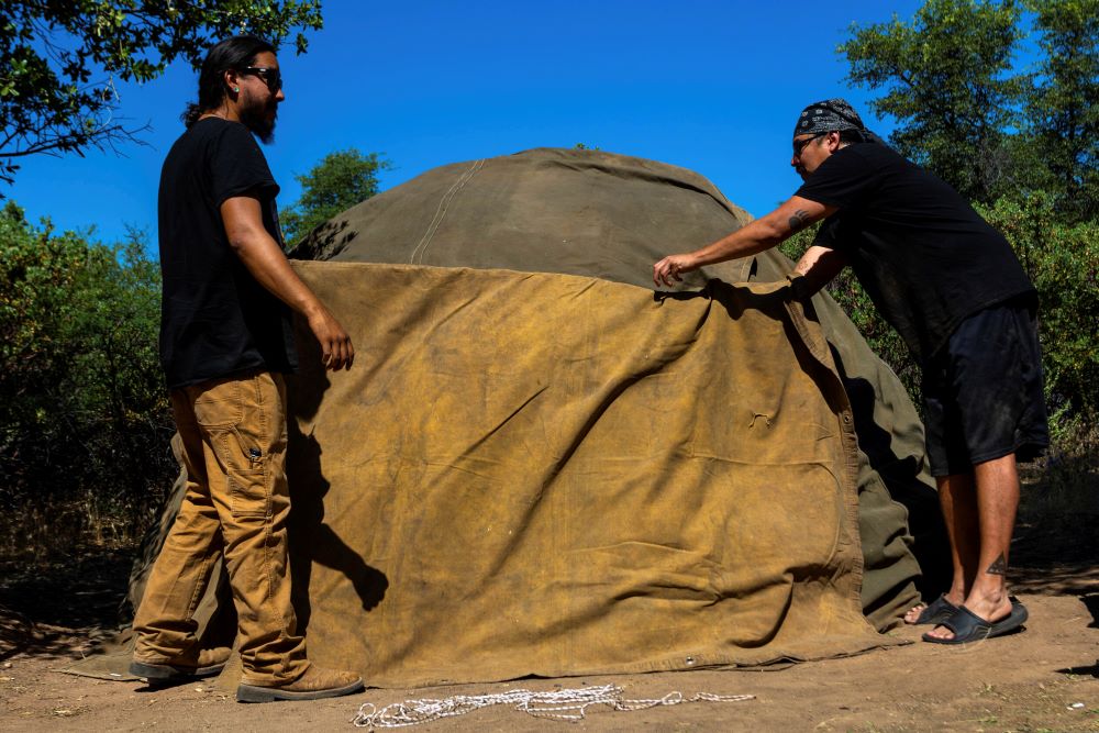 Men work to build a sweat lodge on Oak Flat Campground, a sacred site for Native Americans located 70 miles east of Phoenix, on June 3, 2023, in Miami, Ariz. Resolution Copper Mining, a joint subsidiary of British and Australian mining giants, Rio Tinto and BHP, has proposed a massive copper mine on the flats, which could threaten spiritual practices and heritage. (AP Photo/Ty O'Neil)