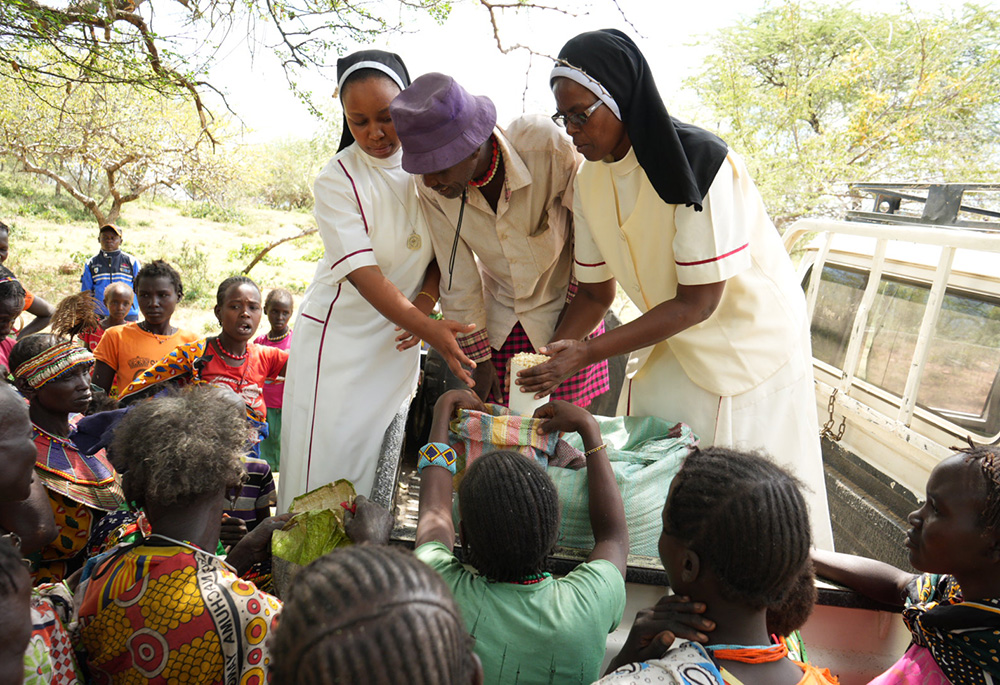 In Sugut village, East Pokot, Srs. Jannifer Hiuhu and Annestacia Wanza distribute food rations to women with the assistance of community elder Peter Chapiral. The aid is part of the "Food for Women and the Elderly" program from the Incarnate Word Sisters, which aims to provide sustenance for women who serve as the primary breadwinners in rural Pokot. (GSR photo/Wycliff Peter Oundo)