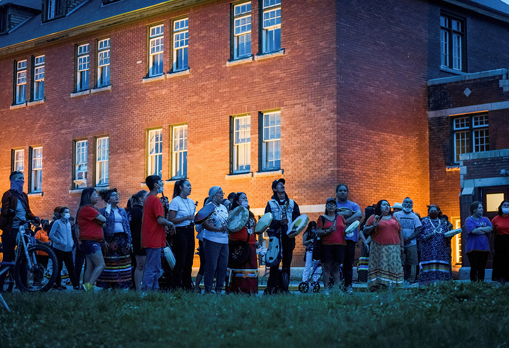 Kamloops residents and First Nations people gather to listen to drummers and singers at a memorial in front of the former Kamloops Indian Residential School in British Columbia, May 31, 2021. (CNS/Reuters/Dennis Owen)