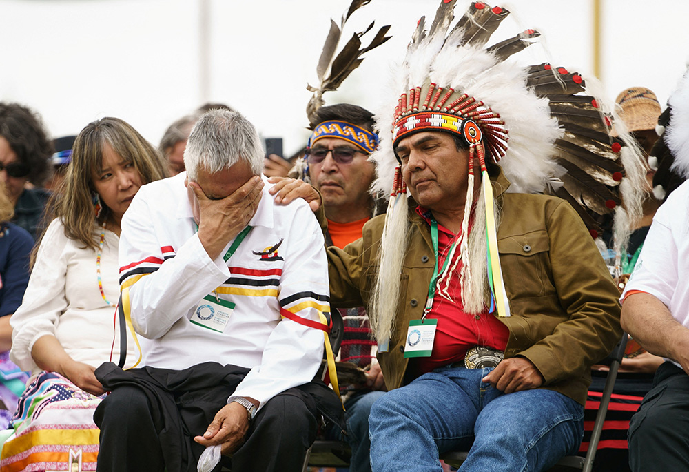 A man is comforted by an Indigenous leader during ceremonies in Maskwacis, Alberta, July 25, 2022, where Pope Francis apologized to Canada's native people on their land for the church's role in schools where Indigenous children were abused. (CNS/Adam Scotti, Prime Minister's Office handout via Reuters)