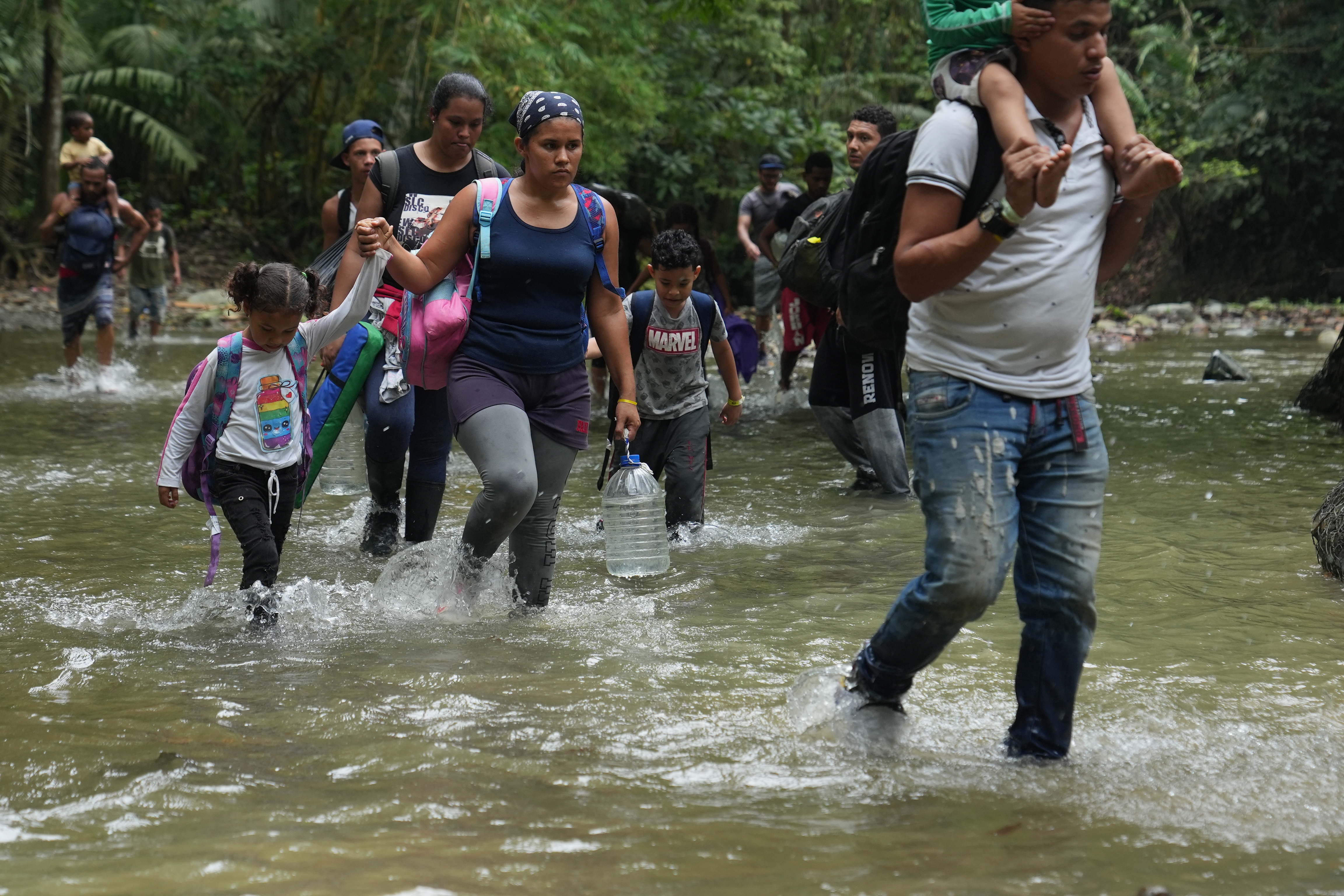 Una migrante venezolana y su hijo, al igual que otras madres con los suyos, comienzan la caminata por el Tapón del Darién atravesando un río el domingo 30 de abril de 2022. El viaje por la selva virgen dura de dos a tres días.  (Foto: GSR /Manuel Rueda)