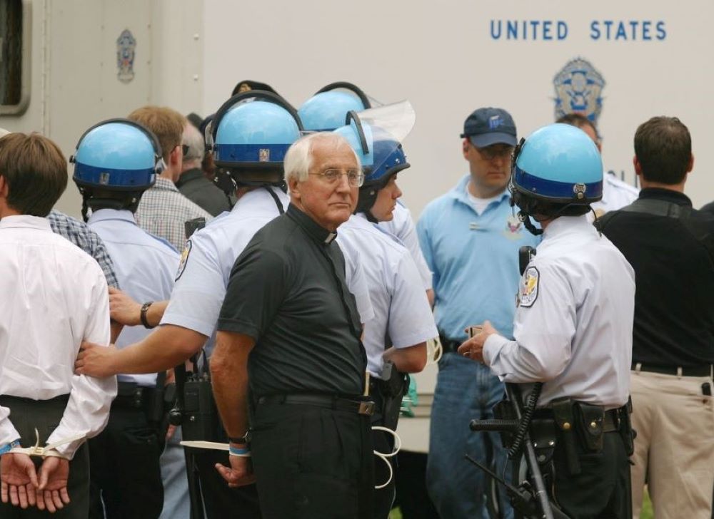 Auxiliary Bishop Thomas Gumbleton of Detroit is handcuffed during his arrest at Lafayette Park in Washington, D.C., March 26, 2003. He was among more than 60 people arrested during the war protest, sponsored by groups including Pax Christi USA and Maryknoll Global Concerns. (CNS/Bob Roller) 
