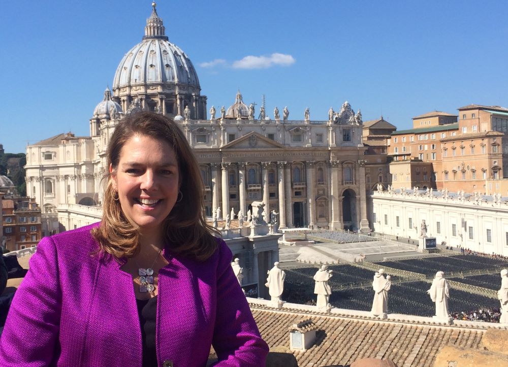 Kerry Alys Robinson stands outside on a roof that overlooks St. Peter's Square. 