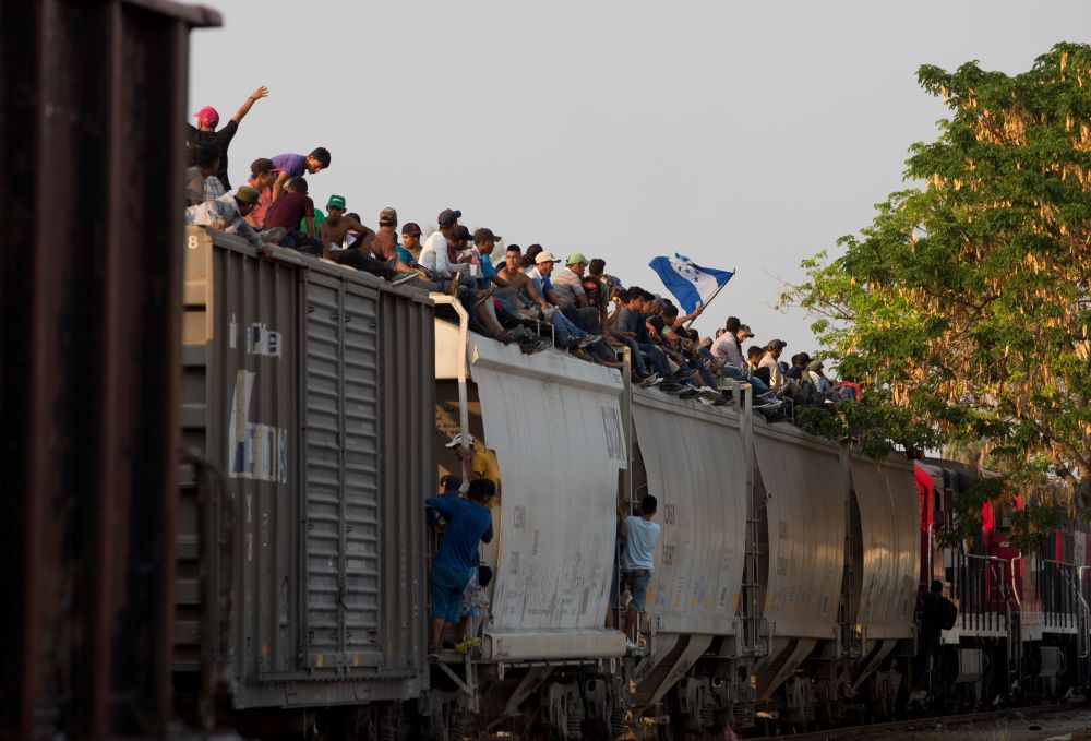 Central American migrants ride atop a freight train during their journey toward the U.S.-Mexico border, in Ixtepec, Oaxaca State, Mexico.