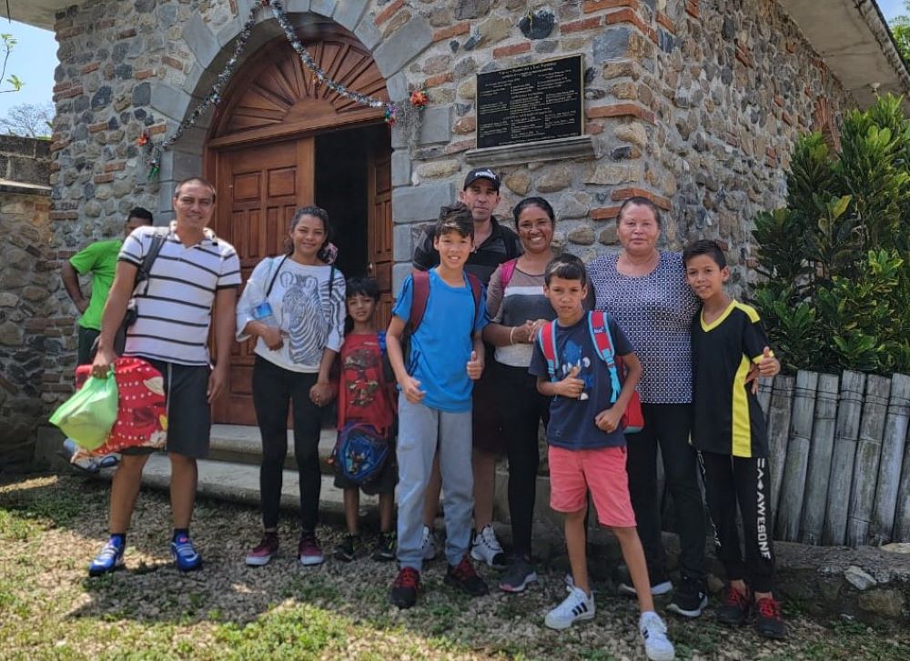 Norma Romero Vasquez (second from right), coordinator of  Las Patronas, stands outside a church with migrant families. (Courtesy of Las Patronas)
