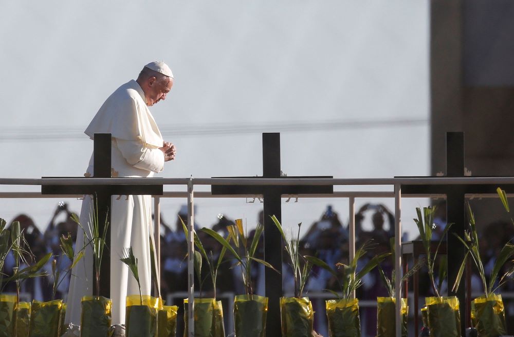 Pope Francis prays overlooking the U.S.-Mexico border before celebrating Mass in Ciudad Juarez, Mexico, Feb. 17, 2016. About 550 guests situated on a levee north of the Rio Grande in Texas took part in the Mass. (CNS/Nancy Wiechec)