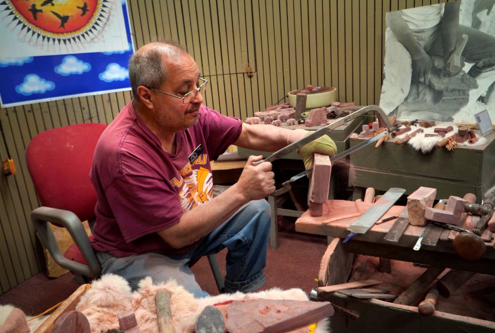 Mark Pederson "Swift Horse," a member of the Sisseton-Wahpeton Dakota Nation and a fourth generation quarrier, saws through a piece of pipestone while demonstrating his craft at the Pipestone National Monument Museum on Wednesday, May 3, 2023, in Pipestone, Minn.