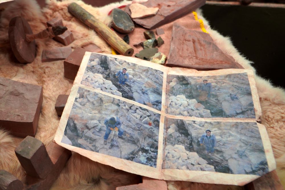 Mark Pederson "Swift Horse," a member of the Sisseton-Wahpeton Dakota Nation and a fourth generation quarrier, shows old photographs of himself digging at his family's quarry at the Pipestone National Monument Museum on Wednesday, May 3, 2023, in Pipestone, Minn.