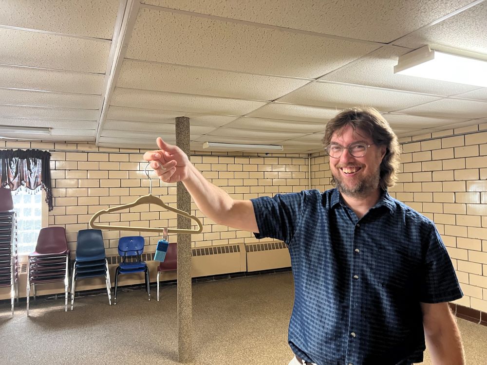 The Rev. Fritz Nelson removes a passive air sampling device, attached to hanger, from the basement of First United Presbyterian Church in East Palestine, Ohio, July 17, 2023. (RNS photo/Kathryn Post)