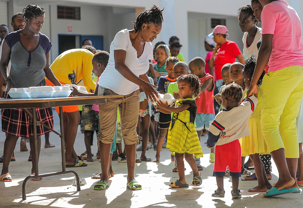 Niños haitianos que escaparon de la violencia en Cité Soleil hacen cola para recibir alimentos en una escuela de Puerto Príncipe el 22 de julio de 2022. El aumento de la violencia relacionada con las bandas ha cerrado el acceso a los servicios de salud en algunas zonas urbanas de Haití dejando a uno de cada 20 niños que viven en Cité Soleil, una comuna asolada por la violencia, en riesgo de morir por desnutrición aguda severa, según advirtió Unicef. (Foto: CNS/Reuters/Ralph Tedy Erol)