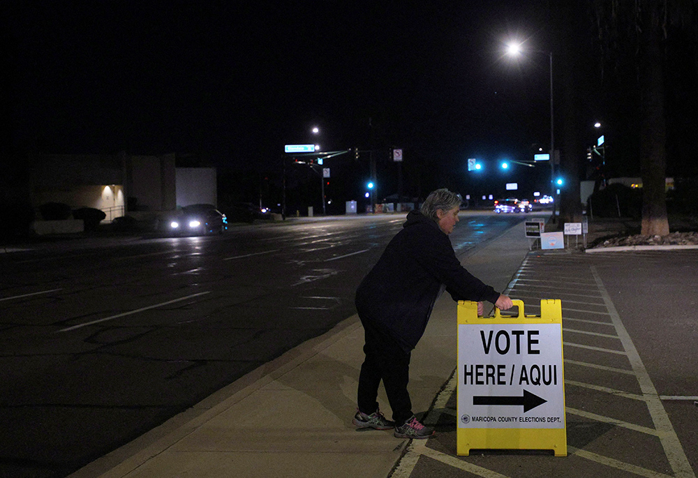 A poll worker puts out a "Vote Here" sign at a Phoenix polling location for the midterm elections Nov. 8, 2022. (CNS/Reuters/Brian Snyder)
