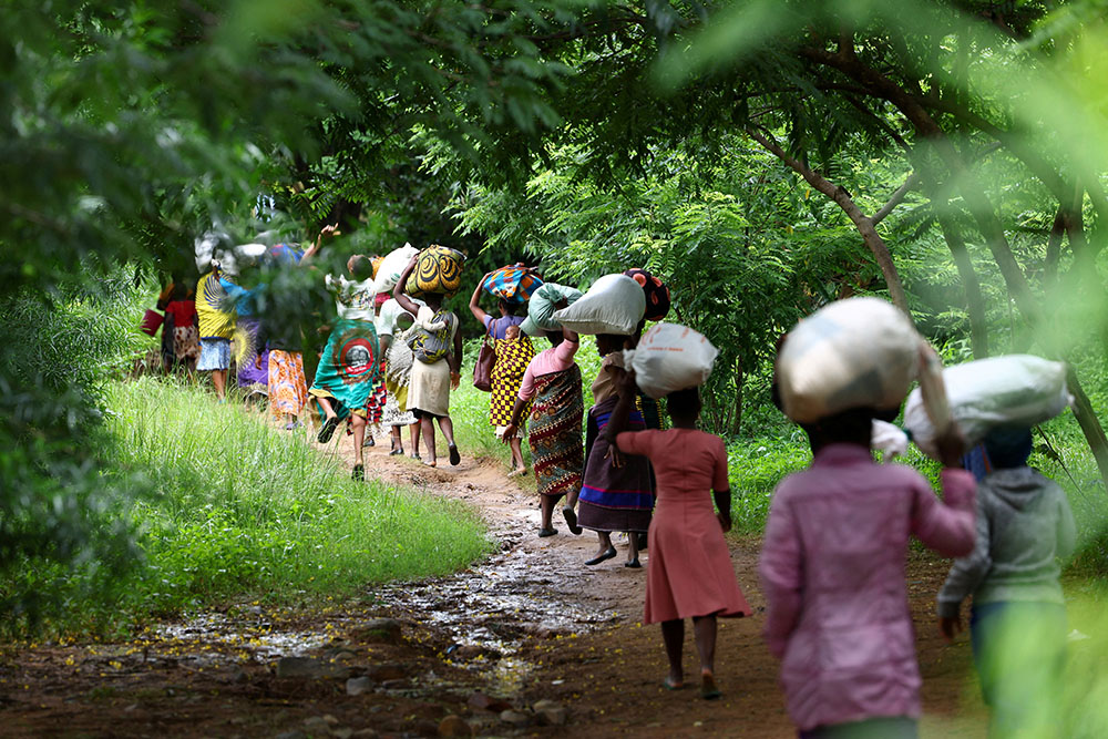 Flood victims from Mtauchira village carry food they received from the Malawi government in Blantyre March 16 in the aftermath of Cyclone Freddy, which destroyed their homes. (OSV News/Reuters/Esa Alexander)