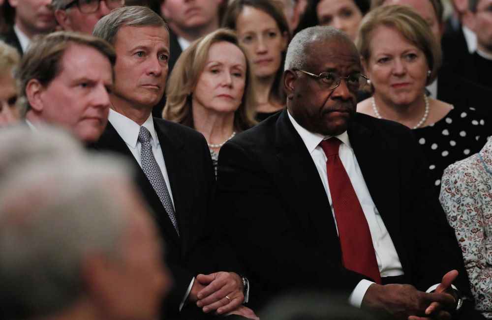 U.S. Supreme Court Chief Justice John Roberts, second from left, and Justice Clarence Thomas, both Catholic, listen during the public swearing-in ceremony for Justice Brett Kavanaugh Oct. 8, 2017, in the East Room of the White House. (CNS/Reuters/Jonathan Ernst)