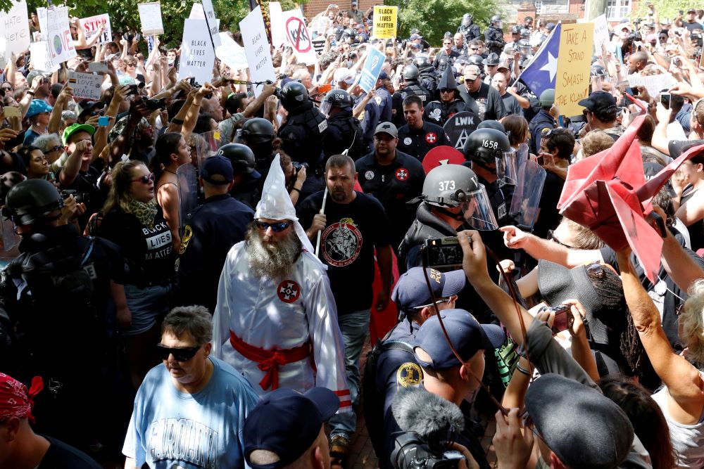 Riot police stand between Ku Klux Klan members and counterprotesters as they arrive in Charlottesville, Virginia, in 2017 to rally against city proposals to remove or make changes to the city's Confederate monuments. 