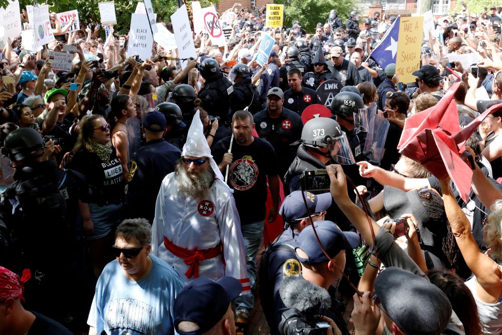 Riot police stand between Ku Klux Klan members and counterprotesters as they arrive in Charlottesville, Virginia, in 2017 to rally against city proposals to remove or make changes to the city's Confederate monuments.