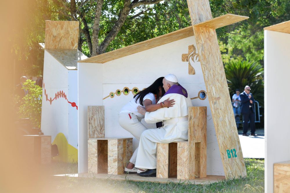 Pope Francis embraces a World Youth Day pilgrim after hearing her confession in Vasco da Gama Garden in Lisbon, Portugal, Aug. 4. The pope administered the sacrament to three pilgrims: young men from Italy and Spain, and the young woman from Guatemala. (CNS/Vatican Media)