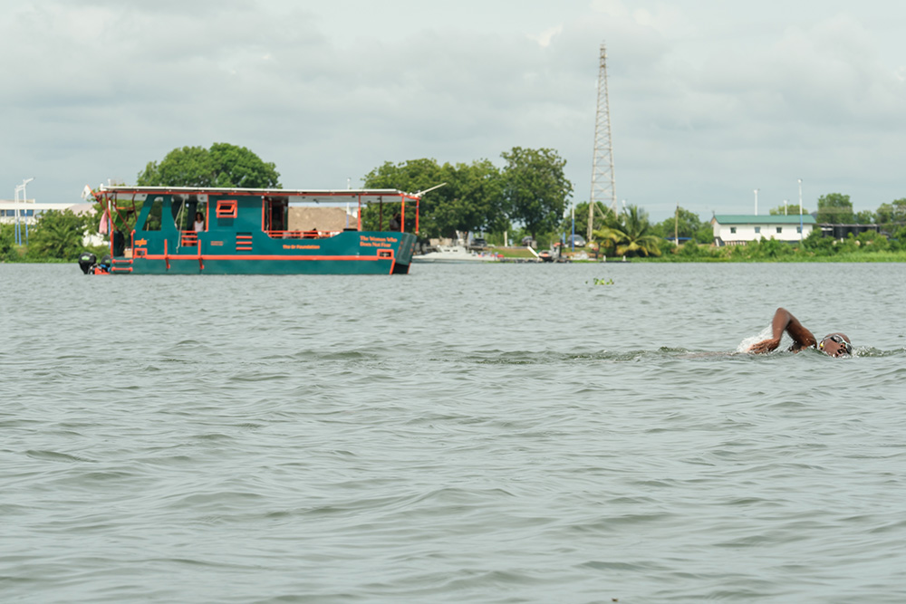 Ghanaian-British athlete Yvette Tetteh swims along the Volta River, while the solar-powered research vessel "The Woman Who Does Not Fear" follows. (Courtesy of the Or Foundation)