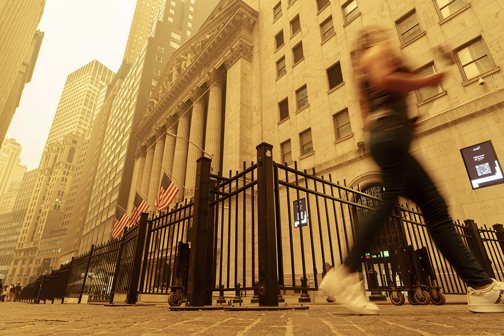 A pedestrian walks past the haze-shrouded New York Stock Exchange building in New York City June 7. Smoke from intense Canadian wildfires severely affected air quality in the Northeastern United States in early June. (AP/J. David Ake)