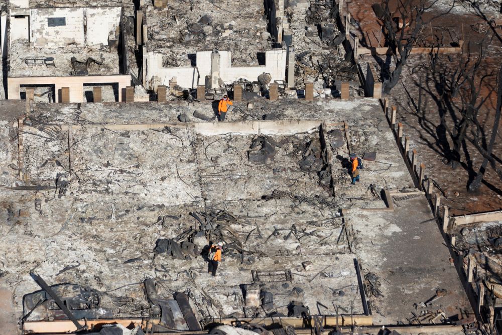 Emergency personnel conduct searches in properties destroyed by wildfires in Lahaina, Hawaii Friday, Aug. 11, 2023.