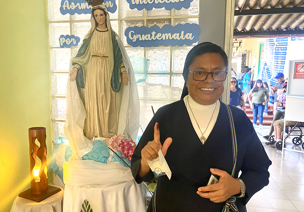 Sr. Rosa María Reyes poses for a photo in front of a statue of Our Lady of the Assumption after voting at a school Aug. 20 in Guatemala City. Guatemala wasn't just voting for a candidate but for change it desperately needs, she said. (NCR photo/Rhina Guidos)