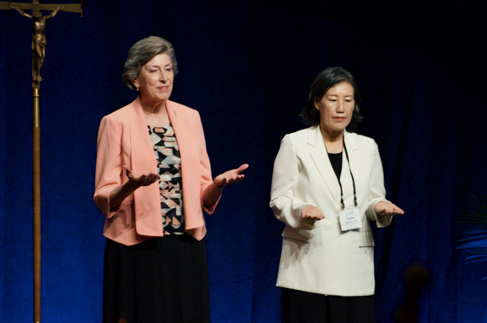 Grand Rapids Dominican Sr. Barbara Reid and Sisters of the Holy Names of Jesus and Mary Sr. Jung Eun Sophia Park receive a blessing before giving a reflection Aug. 10 at the Leadership Conference of Women Religious assembly in Dallas. (GSR photo/Dan Stockman)