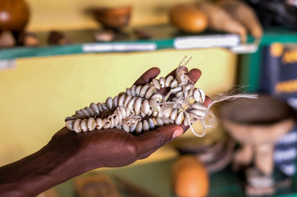 Wilson Kiiza, executive director at the Bugungu Heritage and Information Center in Buliisa, Uganda, holds cowrie shells which are iconic to the Bugungu culture Aug. 4, 2023. 