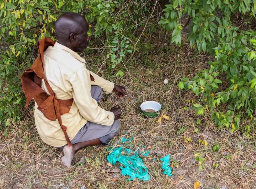 Alex Wakitinti, chief custodian of sacred sites in Buliisa, performs a ritual at a sacred site in the village of Kibambuura , near Buliisa, Uganda, Aug. 4, 2023. 