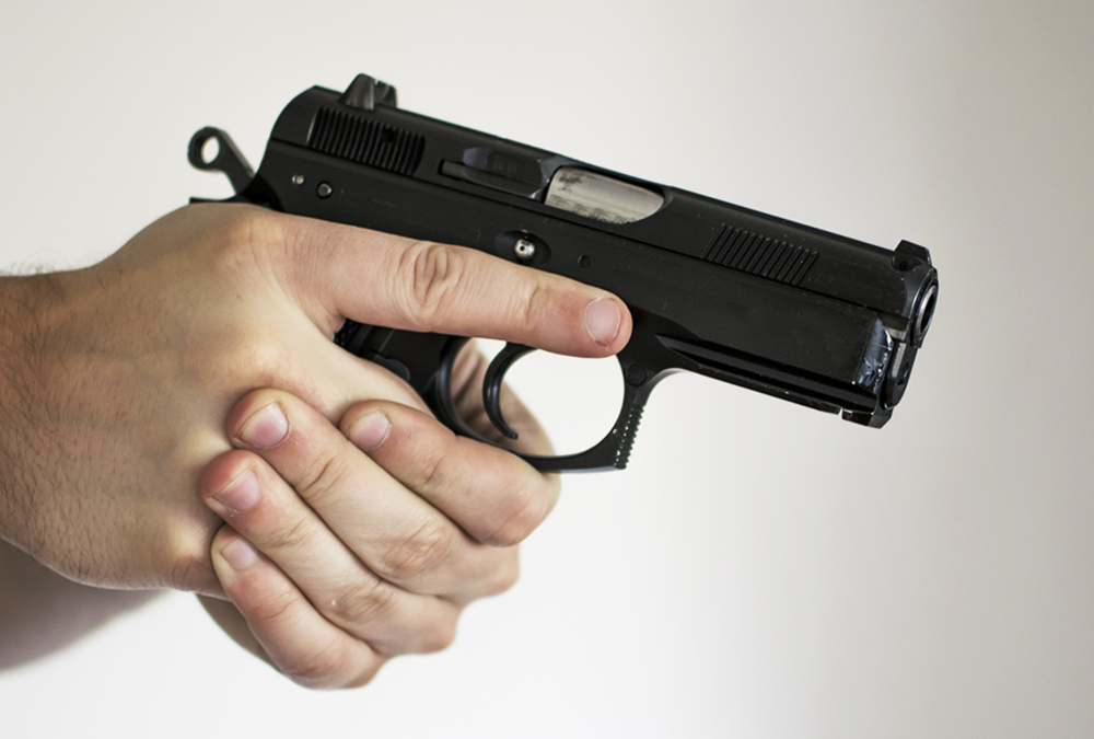 A man's hands pointing a gun (Dreamstime/Seth Anderson)
