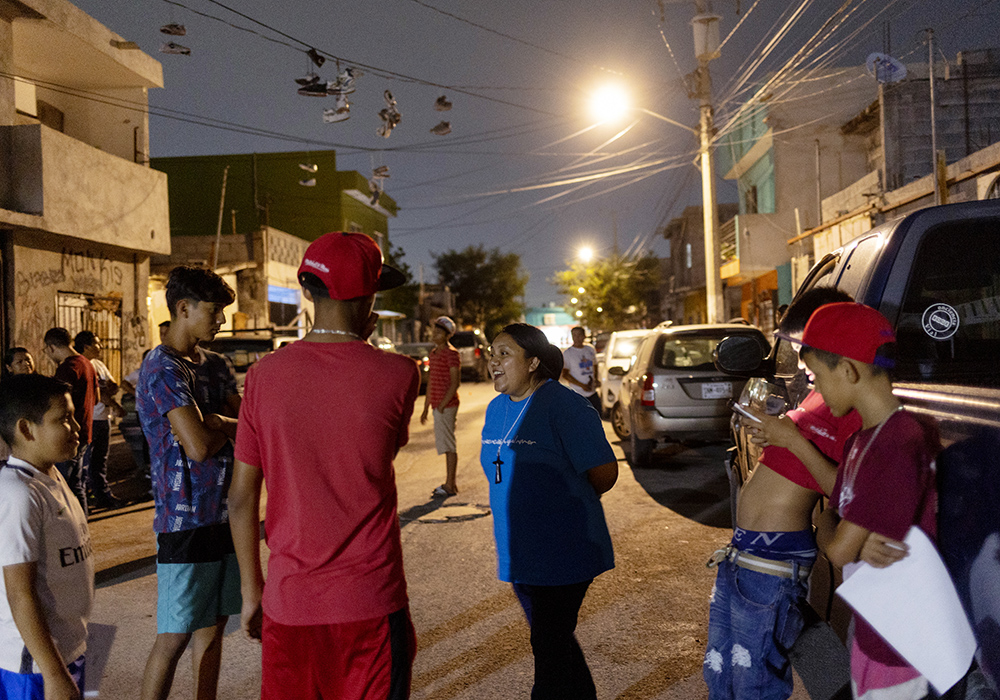 Sr. Sandra López García chats with Los Monckis youth gang members during one of her team's weekly visits to their hangout in Monterrey, Mexico, in May. (Nuri Vallbona)