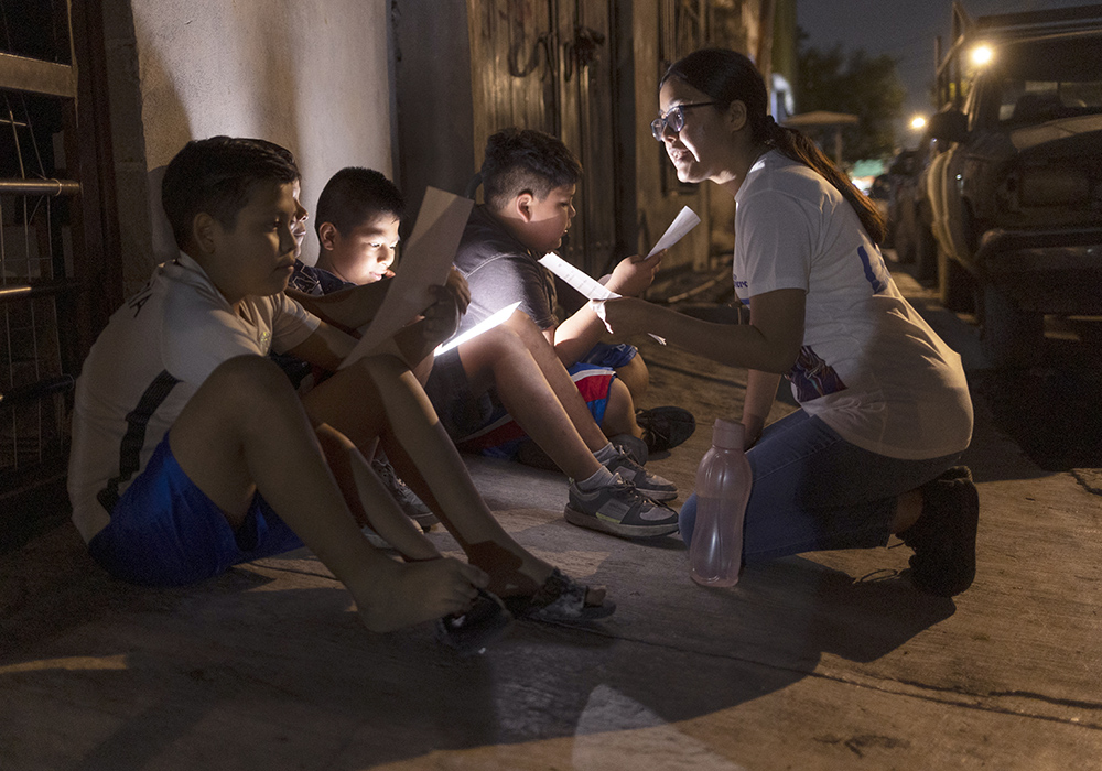 La laica misionera Josseline Montes Jiménez, a la derecha, enseña algunas aclamaciones religiosas a los miembros de Los Monckis durante una de las visitas a la banda en Monterrey, México, el pasado mes de mayo. (Foto: GSR/ Nuri Vallbona)