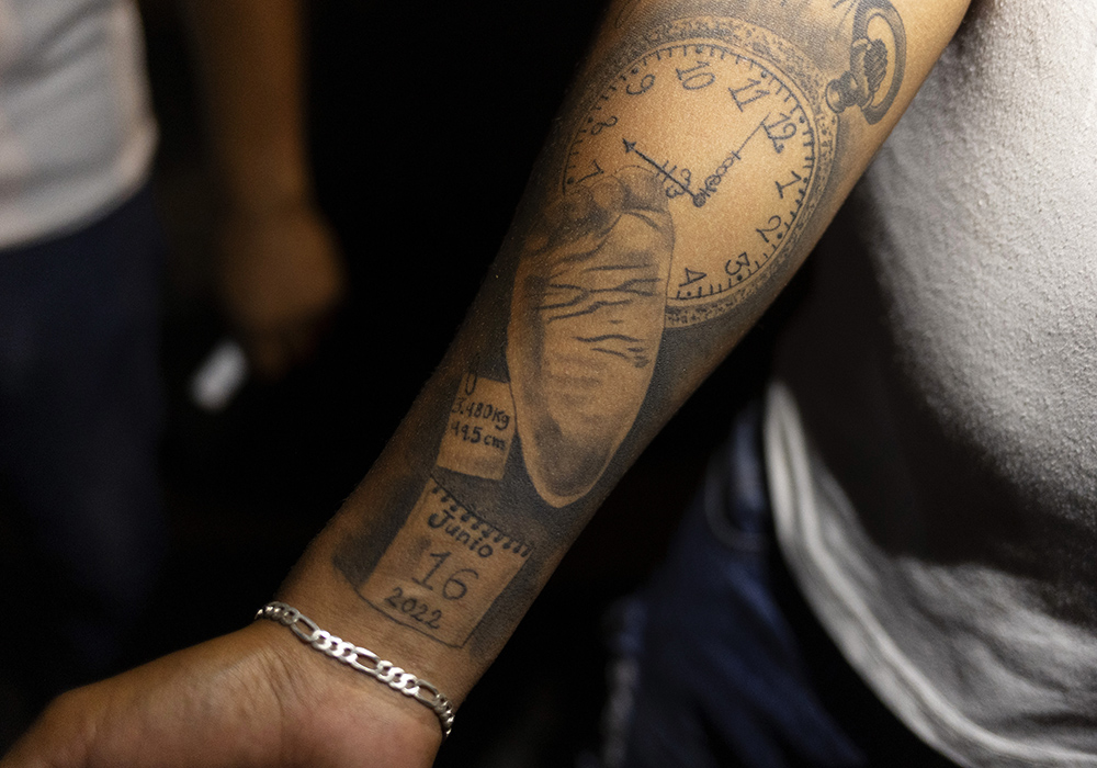 Los Monckis member Fernando Barrientos shows Sr. Sandra López García his tattoo dedicated to his son, Liam, during one of her weekly visits to the youth gang's hangout in Monterrey, Mexico. (Nuri Vallbona)