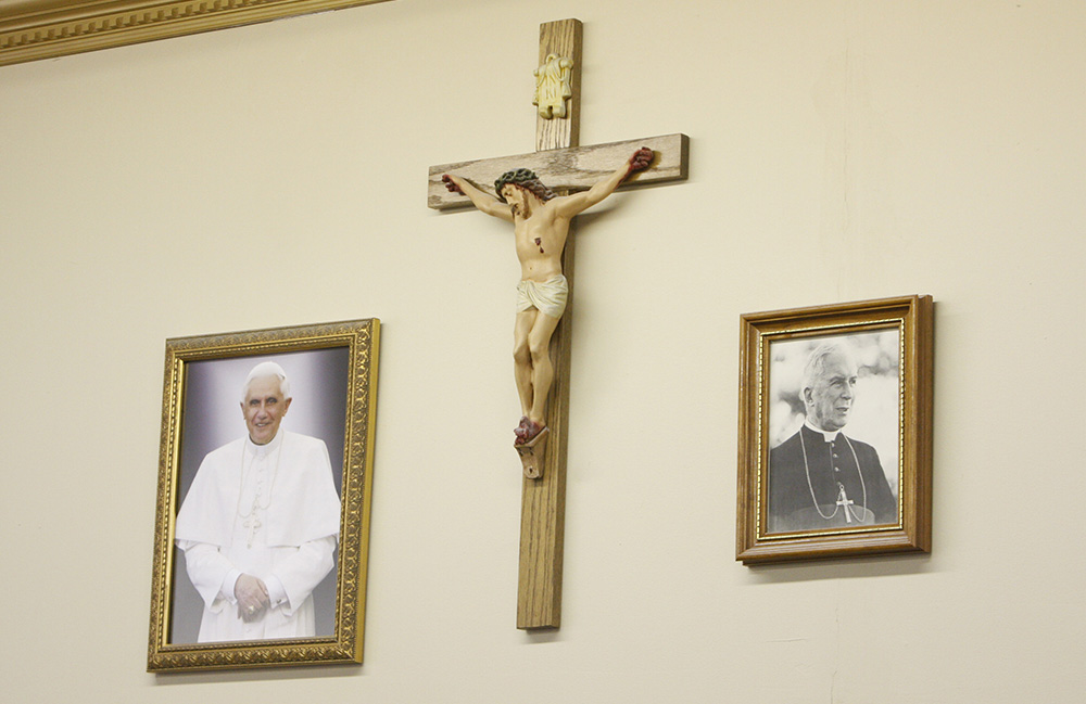 Portraits of Pope Benedict XVI and Archbishop Marcel Lefebvre, founder of the traditionalist Society of St. Pius X, flank a crucifix at St. Michael the Archangel Chapel in Farmingville, New York, in this 2009 photo. (CNS/Gregory A. Shemitz)