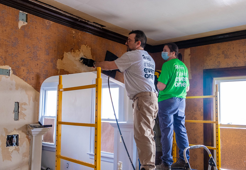 Armand Accordino, a Habitat for Humanity employee and member of the Community of St. Peter, and pastoral minister Martha Ligas strip wallpaper for a Habitat rehab in March 2022. (Megan Dull, SND)