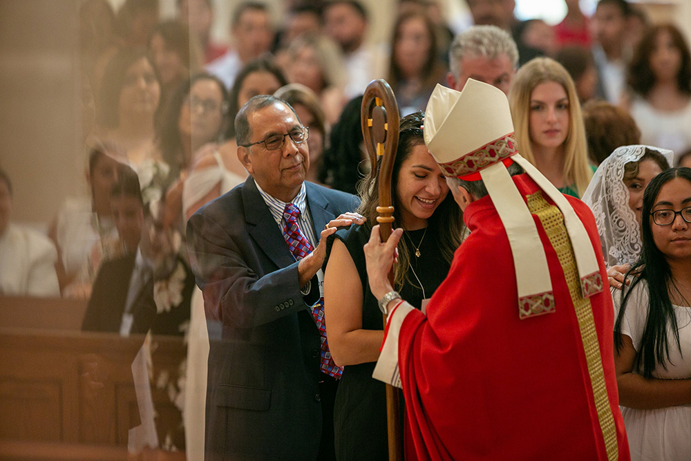 Cardinal Daniel DiNardo of Galveston-Houston anoints the head of a confirmation candidate at the Co-Cathedral of the Sacred Heart in Houston June 5, 2022, during a celebration of the sacrament of confirmation. (CNS/Texas Catholic Herald/James Ramos)