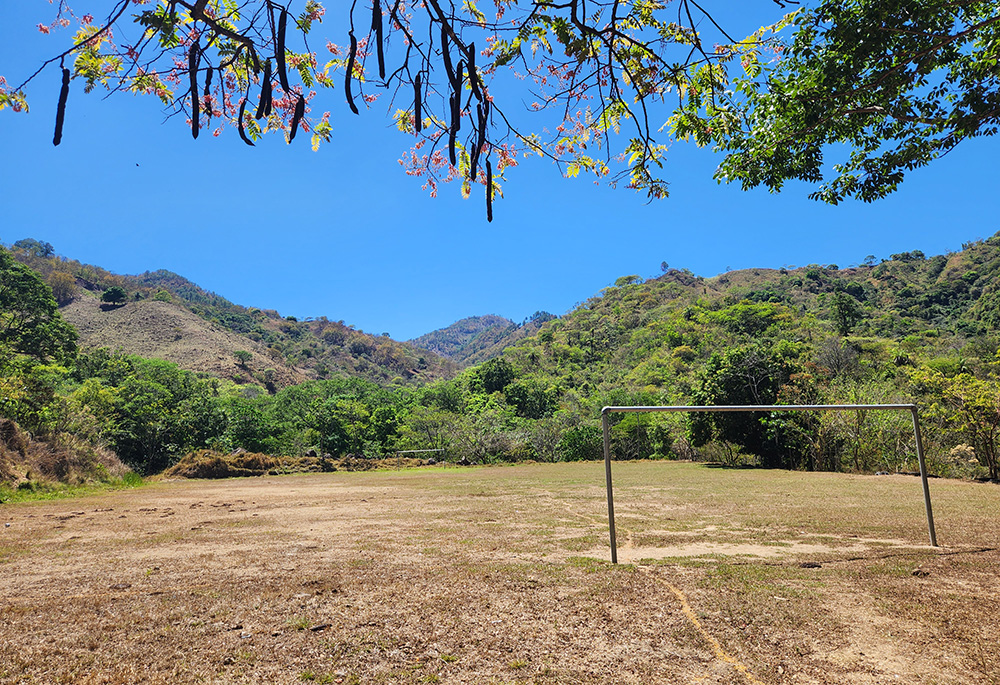 The soccer field at the family farm of Rony Figueroa lies brown and barren on a day in late March. In recent years it typically lies empty, partially a result of many young people having migrated from the rural town due to lack of jobs and other struggles, including those compounded by climate change impacts. (NCR photo/Brian Roewe)