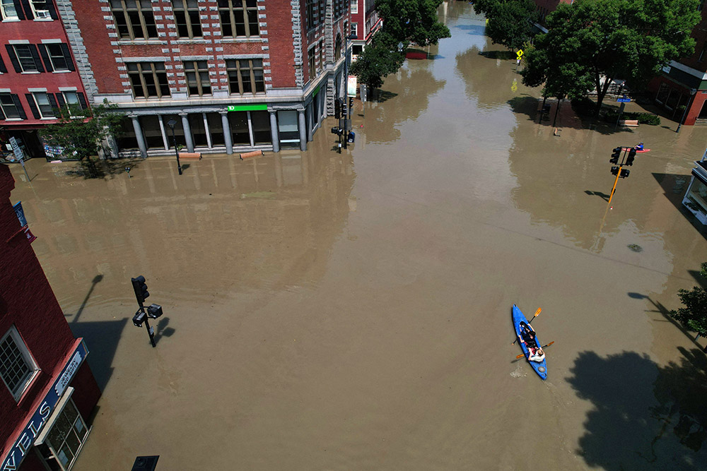 People paddle a kayak on a flooded street in Montpelier, Vermont, on July 11. (OSV News/Reuters/Brian Snyder)
