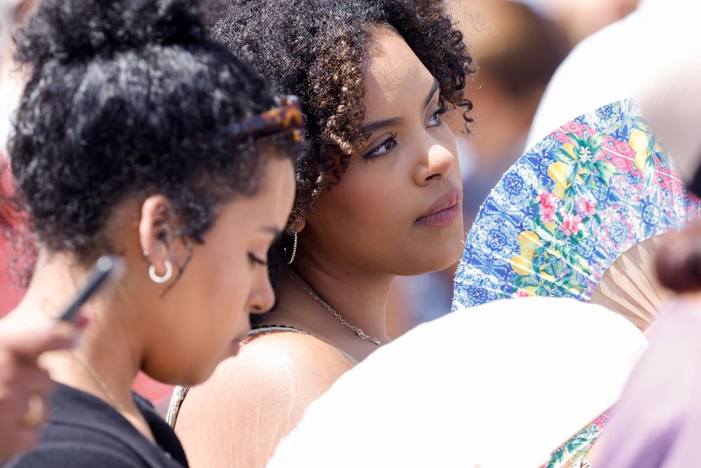 Women fan themselves to cool off from the heat as visitors wait to pray the Angelus with Pope Francis in St. Peter's Square at the Vatican July 16, 2023. (CNS/Lola Gomez)
