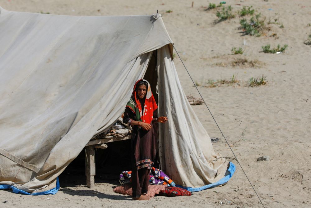 A woman who became displaced following rains and floods during the monsoon season, stands outside her tent in Sehwan, Pakistan, Sept. 13, 2022. (OSV News/Reuters/Akhtar Soomro)