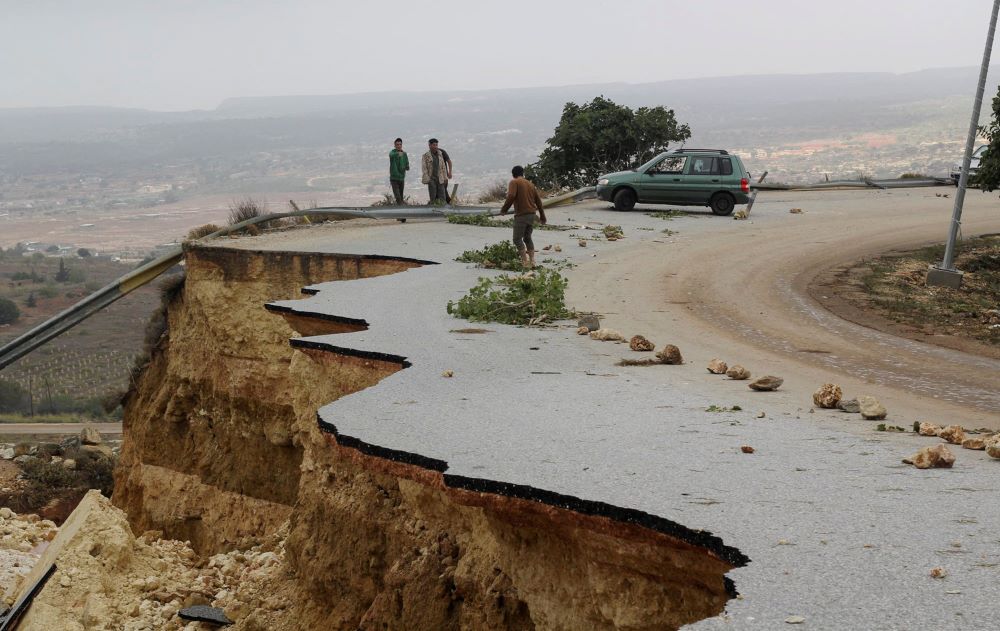 People stand in a damaged road as a powerful storm and heavy rainfall flooded hit Shahhat city, Libya, Sept. 11, 2023. At least 2,000 people have died and 10,000 are believed missing after Storm Daniel dumped so much rain on Libya’s northeast that two dams collapsed sending water flowing into already inundated areas. (OSV News/Reuters/Omar Jarhman)