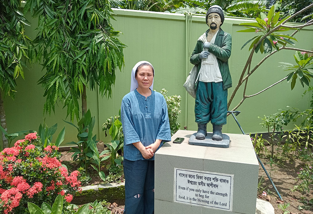 Sr. Andree Lee stands beside a statue of Choi Gui Dong at House of Hope in Gazipur. Choi lived in poverty and had a disability, but Choi took care of 18 other homeless, orphans and disabled people. The founder of Kkottongnae Sisters of Jesus was inspired by his story. (Sumon Corraya)