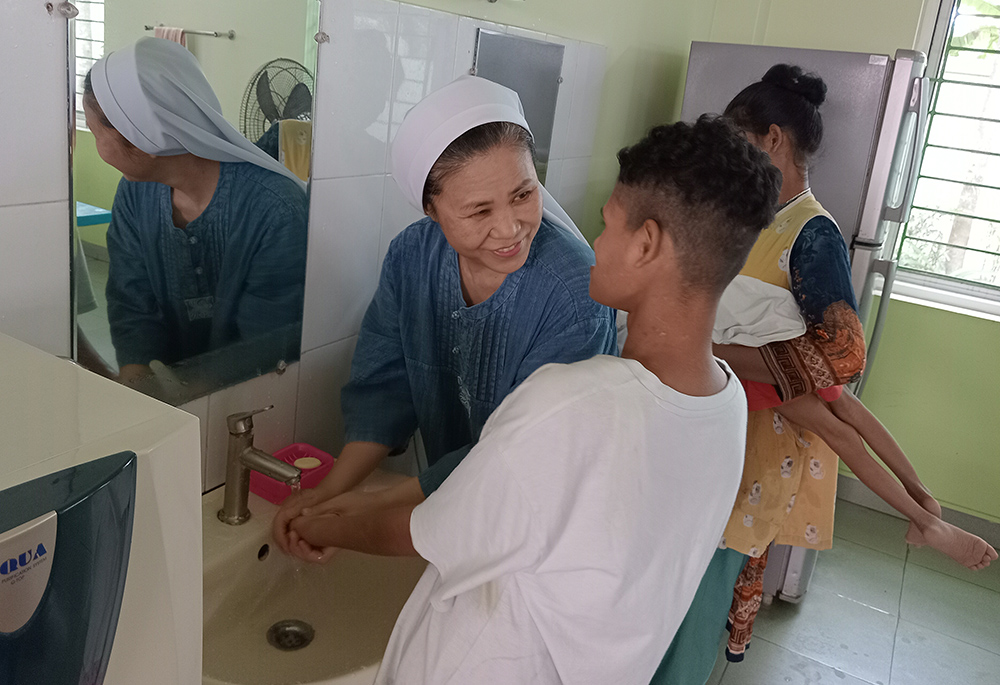 Sr. Andree Lee helps an orphan to wash his arm before lunch. (Sumon Corraya)