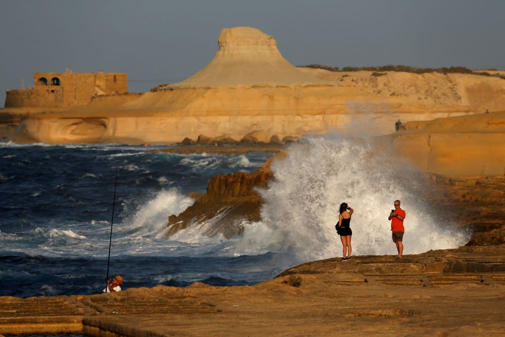 People near waves on Gozo island