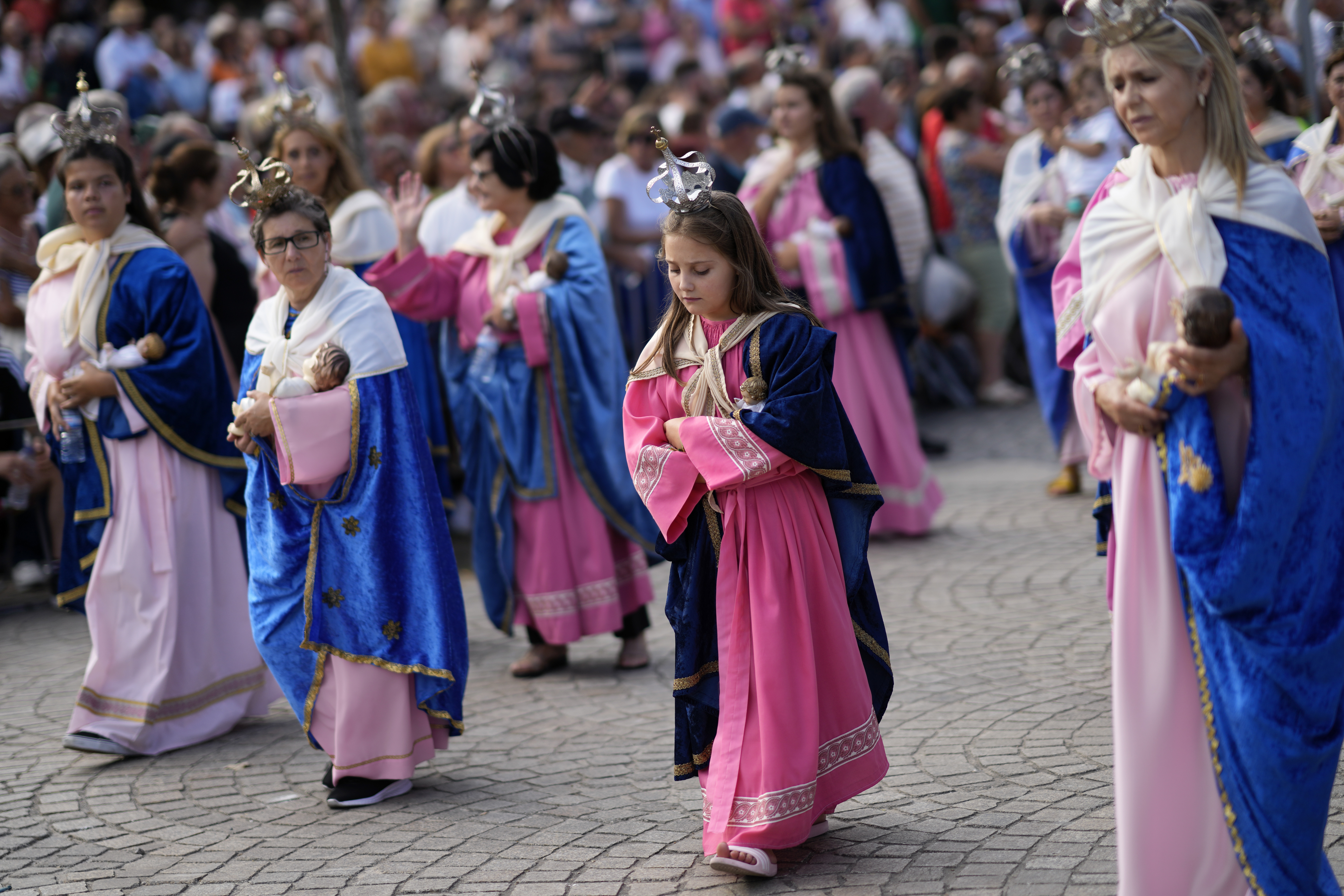 Women and girls dressed in pink and blue like the Virgin statue and carrying Jesus dolls, take part in the Our Lady of Remedies procession in the small town of Lamego, in the Douro River Valley, Portugal, Friday, Sept. 8, 2023. One of Portugal's largest and oldest religious festivals, the two-week celebrations that culminate with the procession, draw thousands. (AP Photo/Armando Franca)