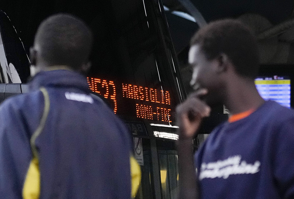Migrants wait to board a bus headed to Marseille, France, on Sept. 12 in Rome. An appeal to welcome and integrate migrants is expected to be at the top of Pope Francis' agenda as he travels to the French port city Sept. 22-23. (AP Photo/Gregorio Borgia)