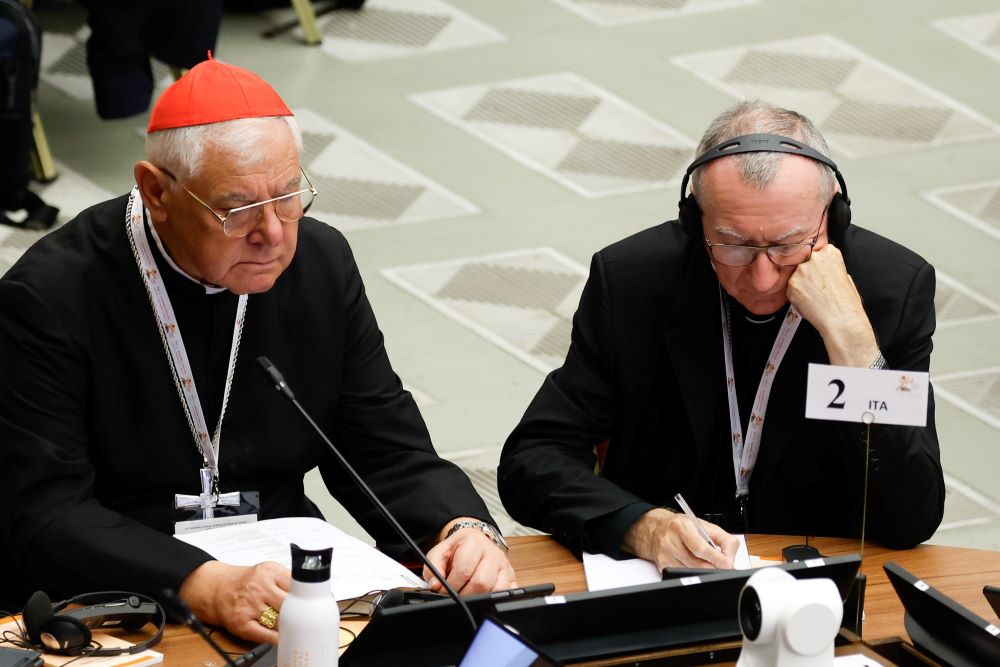 Two people sitting, Cardinal Muller at left