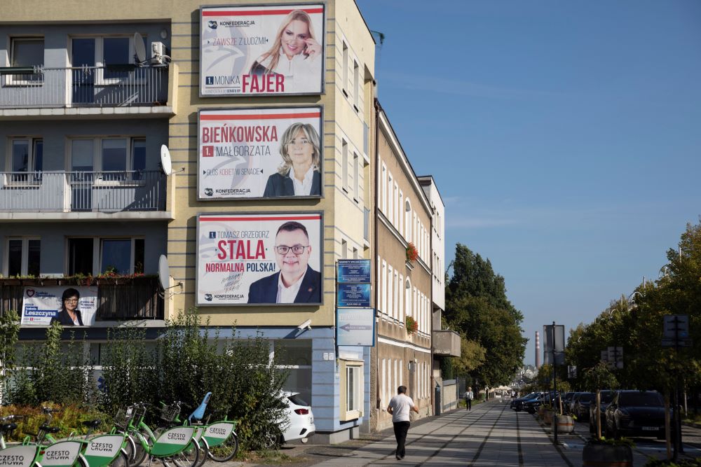 Three campaign posters hang on side of building.