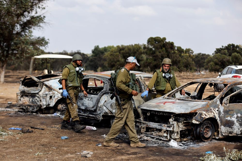 Israeli soldiers inspect the burned cars of festival-goers near Israel's border with the Gaza Strip, in southern Israel, Oct. 13, at the site of a Hamas attack on the Nova Festival. (OSV News/Reuters/Amir Cohen)