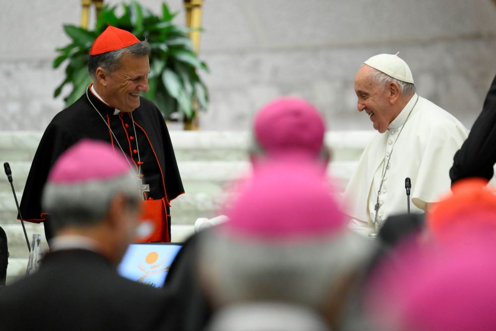 Pope Francis smiles at Cardinal Mario Grech, secretary-general of the Synod of Bishops, as the first assembly of the synod on synodality concludes Oct. 28 in the Paul VI Hall at the Vatican. (CNS/Vatican Media)
